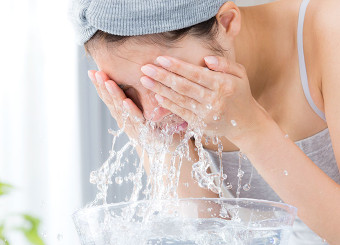 クレンジング洗顔をして顔をすすいでいる女性
